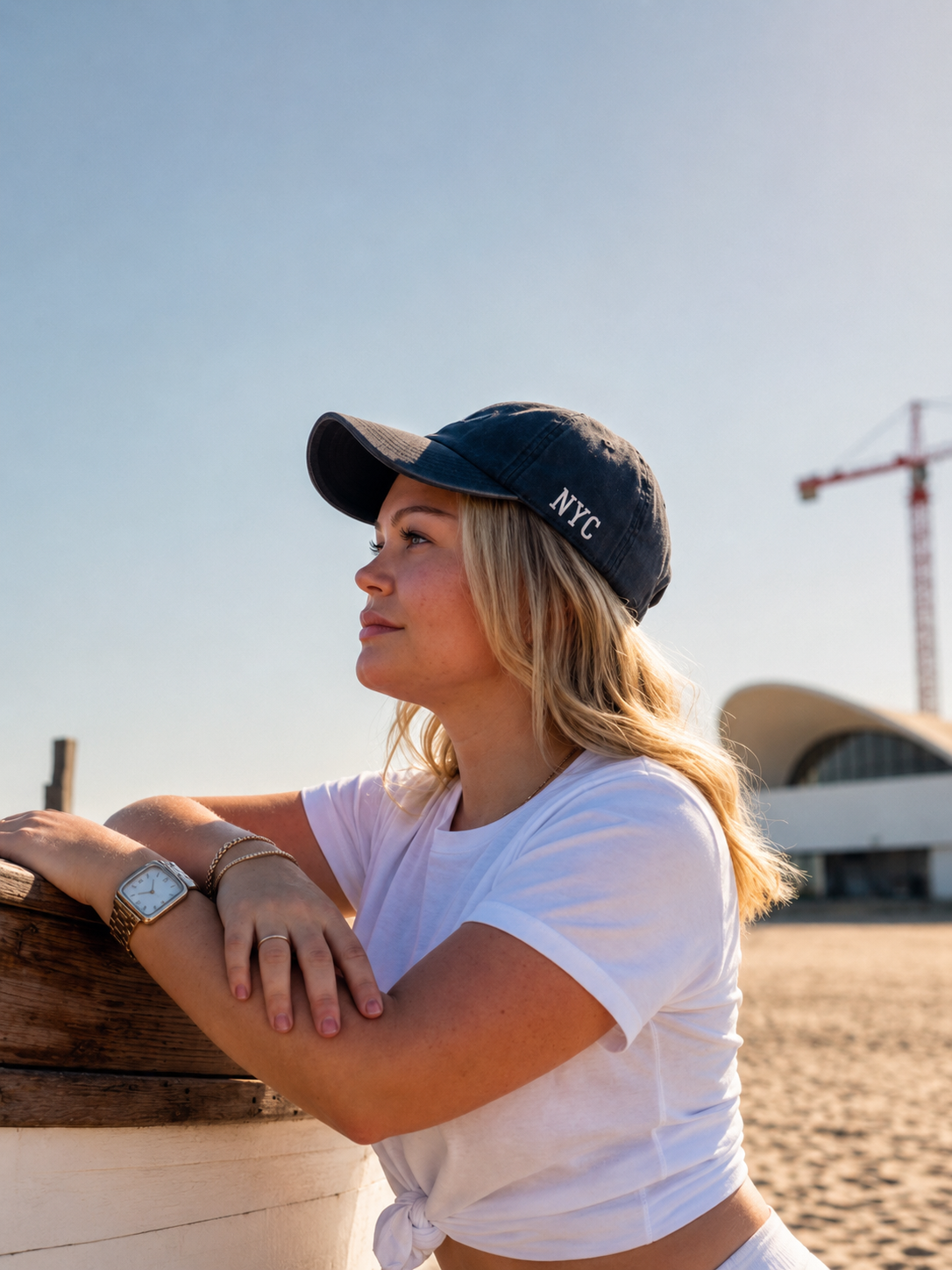 Erika by the sea wearing an NYC cap